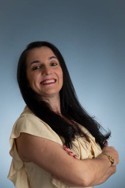 Kollarını kavuşturmuş, kendinden emin genç ve güzel bir kadın. Açık gri arkaplanda izole.