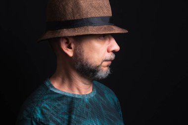 Şapkalı adam. Sağ tarafa bakıyor. Siyah arkaplanda izole.
