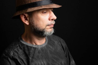 Şapkalı adam. Sağ tarafa bakıyor. Siyah arkaplanda izole.