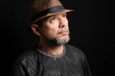 Şapkalı adam. Sağ tarafa bakıyor. Siyah arkaplanda izole.