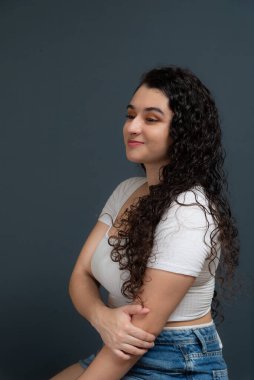 Yan tarafa bakan güzel bir kadının profil portresi. Gri arkaplanda izole.