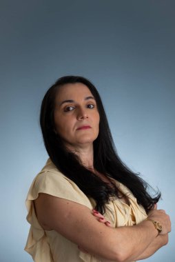 Kollarını kavuşturmuş, kendinden emin genç ve güzel bir kadın. Açık gri arkaplanda izole.