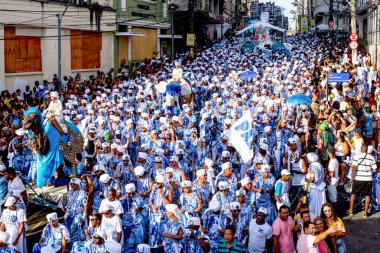 Salvador, Bahia, Brazil - February 11, 2018: Crowd of members of the traditional carnival group Filhos de Gandy, parade in the streets of Salvador, Bahia, during Carnival.
