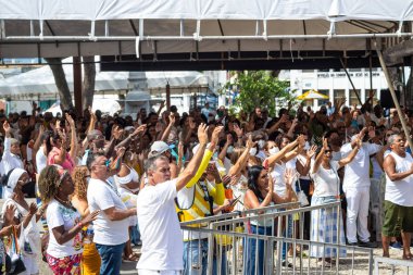 Salvador, Bahia, Brazil - January 06, 2023: Catholic faithful with their hands raised during mass at Senhor do Bonfim church in Salvador, Bahia.