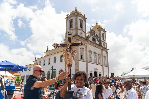 Salvador, Bahia, Brazil - January 06, 2023: Catholics touching the image of Jesus Christ during mass at Senhor do Bonfim church, in the background, in Salvador, Bahia.