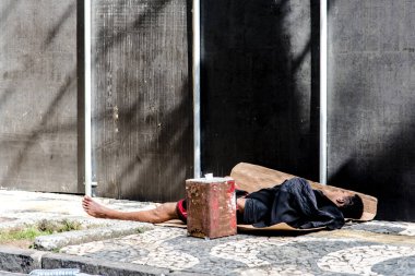 Salvador, Bahia, Brazil - February 09, 2018: Street vendor sleeping on the street after Carnival night in the city of Salvador in Bahia.