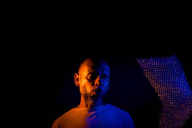 Orta yaşlı bir adam, komik, neşeli, baloncuklarla dolu plastik bir çantayla oynayan. Eğlenceli konsept.