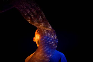 Orta yaşlı bir adam, komik, neşeli, yüzünün önünde köpüklerle dolu plastik bir çantayla oynayan. Eğlenceli konsept.