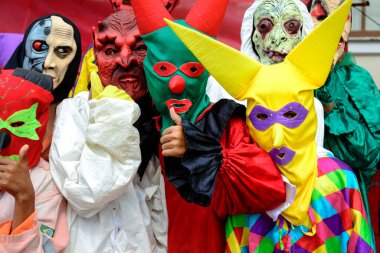 Maragogipe, Bahia, Brazil - February 27, 2017: Group of people dressed in horror costumes against red background at Maragojipe Carnival, Bahia.