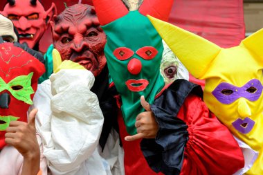 Maragogipe, Bahia, Brazil - February 27, 2017: Group of people dressed in horror costumes against red background at Maragojipe Carnival, Bahia.