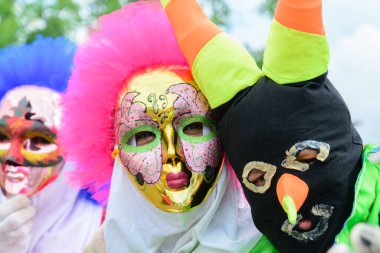 Maragogipe, Bahia, Brazil - February 27, 2017: Three people dressed in colorful costumes and masks at the carnival parade in Maragojipe, Bahia.