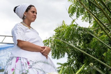 Candomble member guarding gifts for Iemanja's feast in the city of Cachoeira, Bahia.