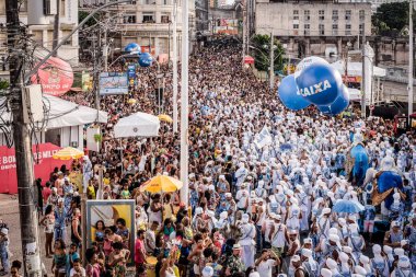 Salvador, Bahia, Brazil - February 11, 2018: Crowd of members of the traditional carnival group Filhos de Gandy, parade in the streets of Salvador, Bahia, during Carnival.