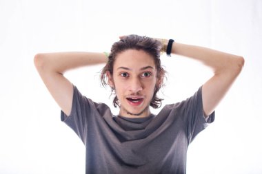 Yakışıklı ve neşeli genç bir adam kameraya bakıp gülümsüyor. İzole edilmiş beyaz arkaplan.