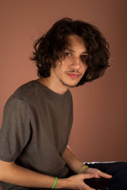 Genç yakışıklı adamın stüdyo portresi. Bisque arkaplanına göre izole.