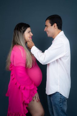 Romantic couple of handsome husband and beautiful pregnant wife posing in studio. studio portrait