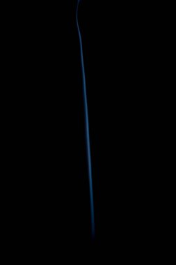 Thread of smoke coming out vertically. Isolated against a black background.