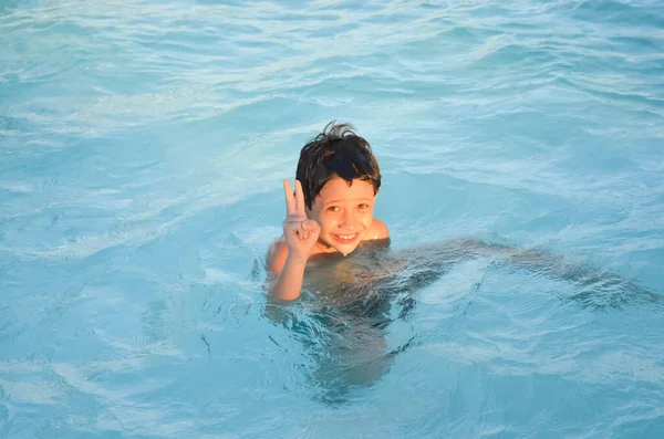 Funny happy boy playing in the pool. Vacation.