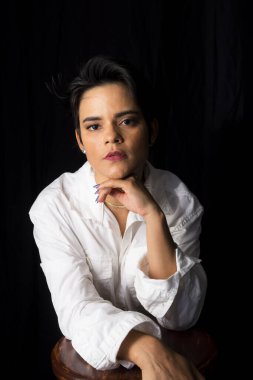Young woman portrait in studio wearing white shirt. Isolated on black background.