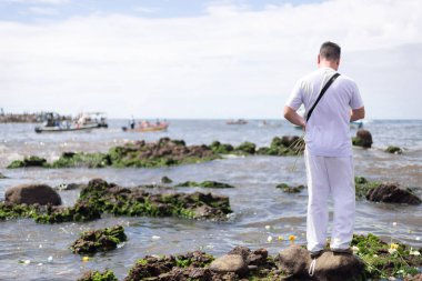 Salvador, Bahia, Brezilya - 02 Şubat 2023: Candomble halkı Rio Vermelho sahilinin kayalıklarında Yemanja 'ya hediyeler sunuyor. Salvador, Bahia.