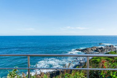 Sea seen from above the shore. Grid, trees and rocks make up the landscape. Salvador, Bahia.