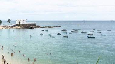 Salvador, Bahia, Brezilya - 14 Ocak 2022: Santa Maria kalesi ve turistlerin Salvador, Bahia 'daki Porto da Barra plajında eğlenmesi.