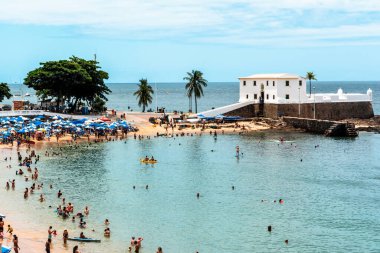 Salvador, Bahia, Brezilya - 14 Ocak 2022: Santa Maria kalesi ve turistlerin Salvador, Bahia 'daki Porto da Barra plajında eğlenmesi.