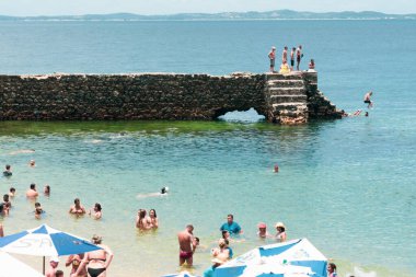 Salvador, Bahia, Brezilya - 14 Ocak 2022: İnsanlar Salvador, Bahia 'daki Porto da Barra plajındaki Forte de Santa Maria iskelesinden suya atlıyorlar.