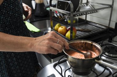 Mutfakta çeşitli malzemelerle cheesecake hazırlayan genç bir kadın. Aile gastronomisi. Salvador, Bahia, Brezilya