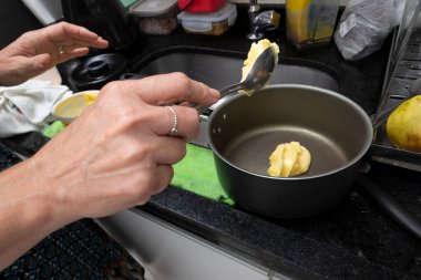 Mutfakta çeşitli malzemelerle cheesecake hazırlayan genç bir kadın. Aile gastronomisi. Salvador, Bahia, Brezilya