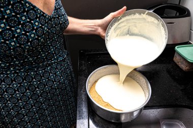Aşçı kadın peynirli keki hazırlamak için malzemeleri karıştırıyor. Plastik alet. Aile gastronomisi.