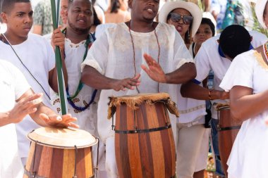 Salvador, Bahia, Brazil - February 02, 2023: candomble members are playing percussion instruments during the party for yemanja, in Salvador, Bahia.