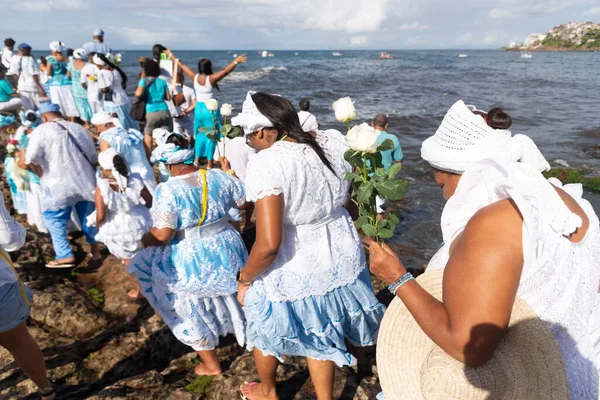 Salvador, Bahia, Brezilya - 02 Şubat 2023: Candomble taraftarları Salvador, Bahia 'daki Yemanja' ya hediye sunmak için Rio Vermelho plajındaki kayaların üzerinde yürüyorlar.