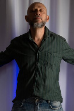 Ayakta duran, sakallı, kel, zayıf, resmi giyinmiş bir adam. Stüdyo portresi. beyaz perde arkaplanı