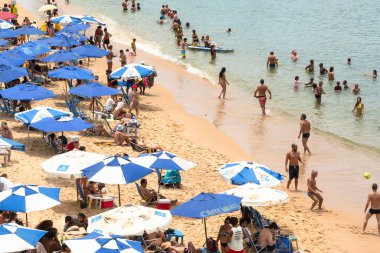 Salvador, Bahia, Brezilya - 14 Ocak 2022: Yüzlerce insan ve turist Salvador, Bahia 'da güneş altında Porto da Barra plajında eğleniyor.