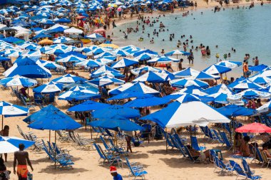 Salvador, Bahia, Brezilya - 14 Ocak 2022: Porto da Barra sahilinde kalabalık güçlü yaz güneşi altında eğleniyor. Salvador, Bahia.