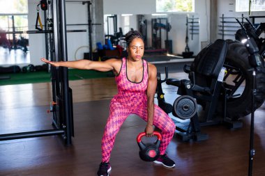 Determined Woman Doing Squat Exercises With Kettlebell. Spine strengthening.