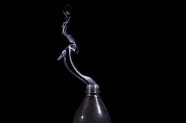 İçinden duman çıkan, izole edilmiş şeffaf bir plastik şişe. Tasarım ögesi.