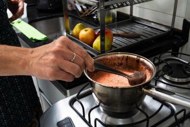 Mutfakta çeşitli malzemelerle cheesecake hazırlayan genç bir kadın. Aile gastronomisi. Salvador, Bahia, Brezilya
