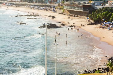 Salvador, Bahia, Brezilya - 22 Ekim 2022: Sıcak bir günde Farol da Barra plajı manzarası. Sahilde bir sürü insan var. Bahia, Salvador 'un turizm beldesi.