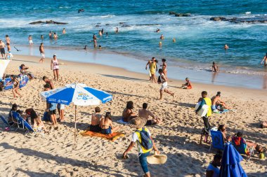 Salvador, Bahia, Brezilya - 22 Ekim 2022: İnsanlar sıcak bir günde Farol da Barra plajında yürüyüp dinleniyorlar. Salvador, Bahia.