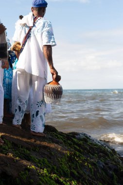 Salvador, Bahia, Brezilya - 02 Şubat 2023: Candomble halkı Rio Vermelho sahilinin kayalıklarında Yemanja 'ya hediyeler sunuyor. Salvador, Bahia.