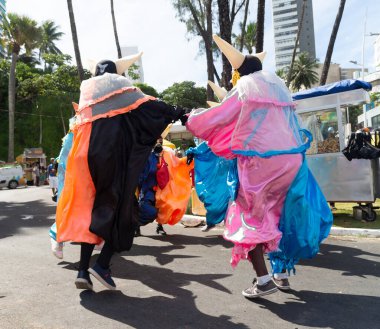 Salvador, Bahia, Brazil - February 11, 2023: Group of masked people are dancing in the street during the pre-carnival Fuzue parade in Salvador, Bahia.