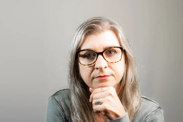 Portrait of beautiful woman wearing eyeglasses. Isolated on gray background.