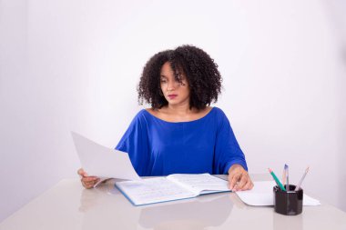 Konsantre olmuş, genç ve güzel bir kadın, çalışma materyali okuyor. Merkez ofis. İşletme yöneticisi.