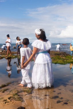 Salvador, Bahia, Brazil - February 02, 2023: Candomble members and supporters are on Rio Vermelho beach offering gifts to Yemanja. City of Salvador, Bahia.
