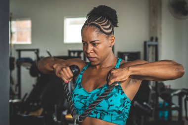 Spor salonunda çalışan kaslı bir kadın. Stüdyoda spor salonu.