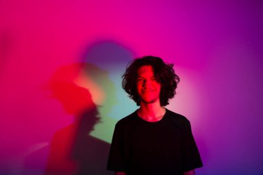 Fotografik arka planda renkli gölgeleri olan genç yakışıklı bir adamın portresi. rgb renkleri