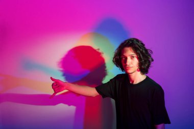 Fotografik arka planda renkli gölgeleri olan genç yakışıklı bir adamın portresi. rgb renkleri