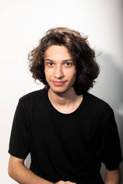 Beyaz arka planda gölgeli uzun saçlı yakışıklı bir adamın portresi..